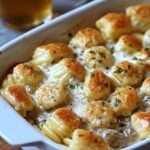 A bowl of Caprese Pasta Salad with farfalle, cherry tomatoes, mozzarella pearls, and fresh basil.