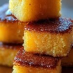 A golden-brown square of honey butter cornbread with a glistening glaze.