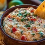 A creamy bowl of Viral Boat Dip topped with green onions and served with corn chips.