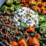A vibrant ground beef power bowl with roasted sweet potatoes, sautéed spinach, and fresh avocado slices.