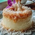 A golden brown Brazilian custard cake sliced on a white plate with shredded coconut on top.