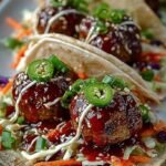 Platter of flour tortillas filled with glazed Korean BBQ meatballs, purple cabbage, and kimchi crema.