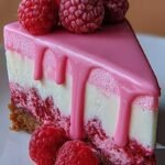 A creamy pink velvet raspberry cheesecake with a decorative red swirl on a graham cracker crust.