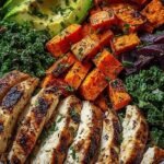 A colorful chicken sweet potato power bowl with grilled chicken, roasted sweet potatoes, quinoa, and avocado.