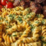 A large skillet filled with creamy Cajun beef and rotini pasta topped with fresh parsley.