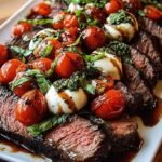 Grilled flank steak topped with fresh mozzarella, sliced tomatoes, and basil leaves with a balsamic drizzle