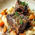 Fork-tender beef short ribs served over mashed potatoes with a rich red wine sauce.