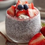 Two glass jars filled with creamy strawberry chia pudding topped with fresh sliced strawberries