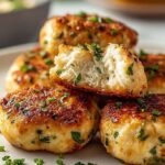 Golden brown air fried chicken cubes garnished with fresh parsley and lemon slices on a white serving plate.