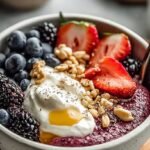 A high-protein cottage cheese breakfast bowl topped with fresh strawberries, blueberries, chia seeds, and almonds.