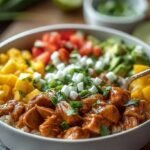 A colorful burrito bowl with ground turkey, roasted asparagus, black beans, and avocado on a bed of cauliflower rice.