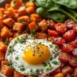 A colorful breakfast plate with soft scrambled eggs, smoked salmon, grilled asparagus spears, and sliced avocado.
