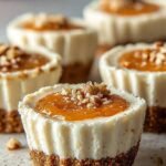 Mini carrot cake cheesecake cups topped with chopped walnuts on a white plate