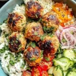 A tray of golden brown chicken meatballs seasoned with red harissa and fresh parsley.