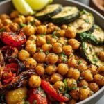 A vibrant Mediterranean Chickpea Bowl with roasted zucchini, peppers, and creamy tahini dressing.