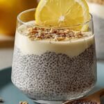 Four glass jars filled with creamy lemon chia pudding topped with fresh lemon zest and berries on a bright kitchen counter.