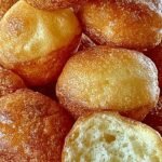 A plate of golden brown mini pancake poppers served with maple syrup and fresh berries.