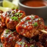 Golden brown BBQ chicken skewers in an air fryer basket with a honey glaze