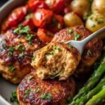 Six colorful bell peppers stuffed with turkey and quinoa topped with melted cheese in a baking dish.