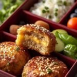 Divided meal prep containers filled with hard-boiled eggs, turkey slices, cheese, almonds, and fresh vegetables.