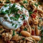 A bowl of creamy white chicken chili topped with cilantro and lime wedges.