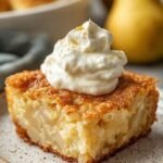 A golden brown yogurt bake topped with sliced pears in a square baking dish.