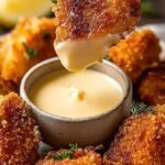 Golden brown crispy air fryer chicken bites in a black basket