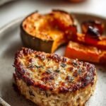 A sheet pan filled with golden roasted chicken cubes, orange butternut squash, and charred Brussels sprouts.