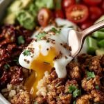 A colorful burrito bowl with roasted sweet potatoes, quinoa, ground turkey, kale, and avocado slices