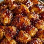 A golden brown whole roasted chicken with lemon and orange slices in a roasting pan