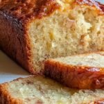 A sliced banana milk morning cake on a wire rack