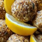 A plate of round lemon poppy seed energy bites with fresh lemon zest and oats.