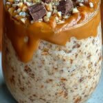 A stack of golden brown cottage cheese protein cookies with dark chocolate chips on a wire rack.