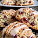 Golden brown cranberry orange scones on a baking sheet sprinkled with sugar