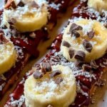 A tray of frozen chocolate banana bark with peanut butter layers and sea salt