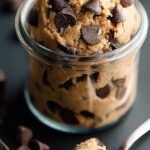 A bowl of high-protein edible cookie dough topped with sugar-free chocolate chips and a spoon.