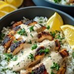 A bowl of fluffy jasmine rice topped with golden sautéed chicken and a rich, creamy white garlic sauce garnished with fresh parsley.