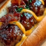 Golden brown bacon cheeseburger meatballs on a baking sheet with melted cheddar cheese