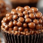 Chocolate Peanut Butter Rice Krispie Cups in a muffin tin with a glossy chocolate top.