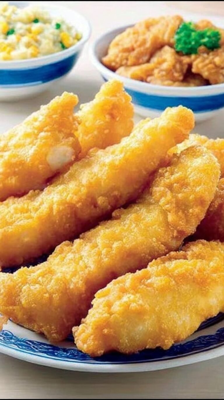 Golden brown fried fish fillets coated in a crispy, airy batter sitting on a wire rack.