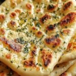 Golden brown garlic flatbread topped with herbs in an air fryer basket