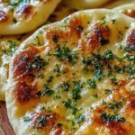 Golden brown garlic flatbread brushed with parsley butter in an air fryer basket